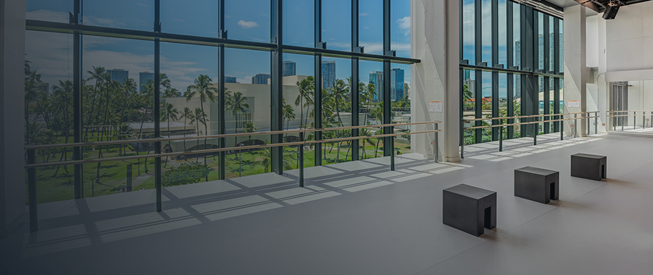 Dance studio with grey floor and floor to ceiling windows.